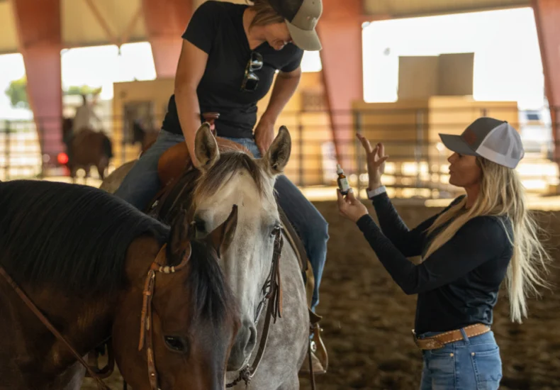 Explanation of CBD product given by someone who is located off a horse to someone on a horse