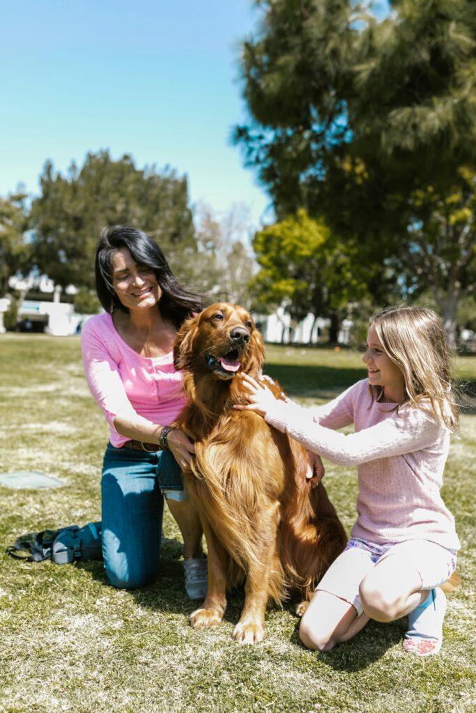 A picture of a dog smiling and happy with a mom and daughter